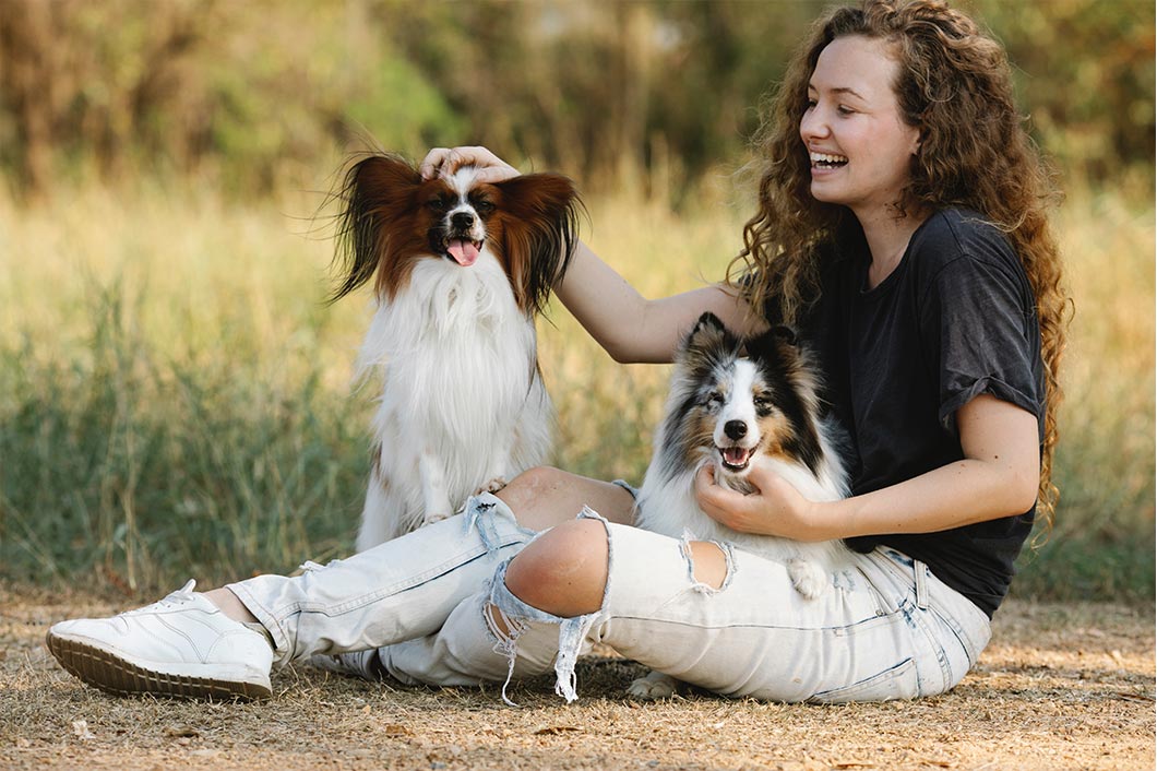 girl-playing-with-two-dogs